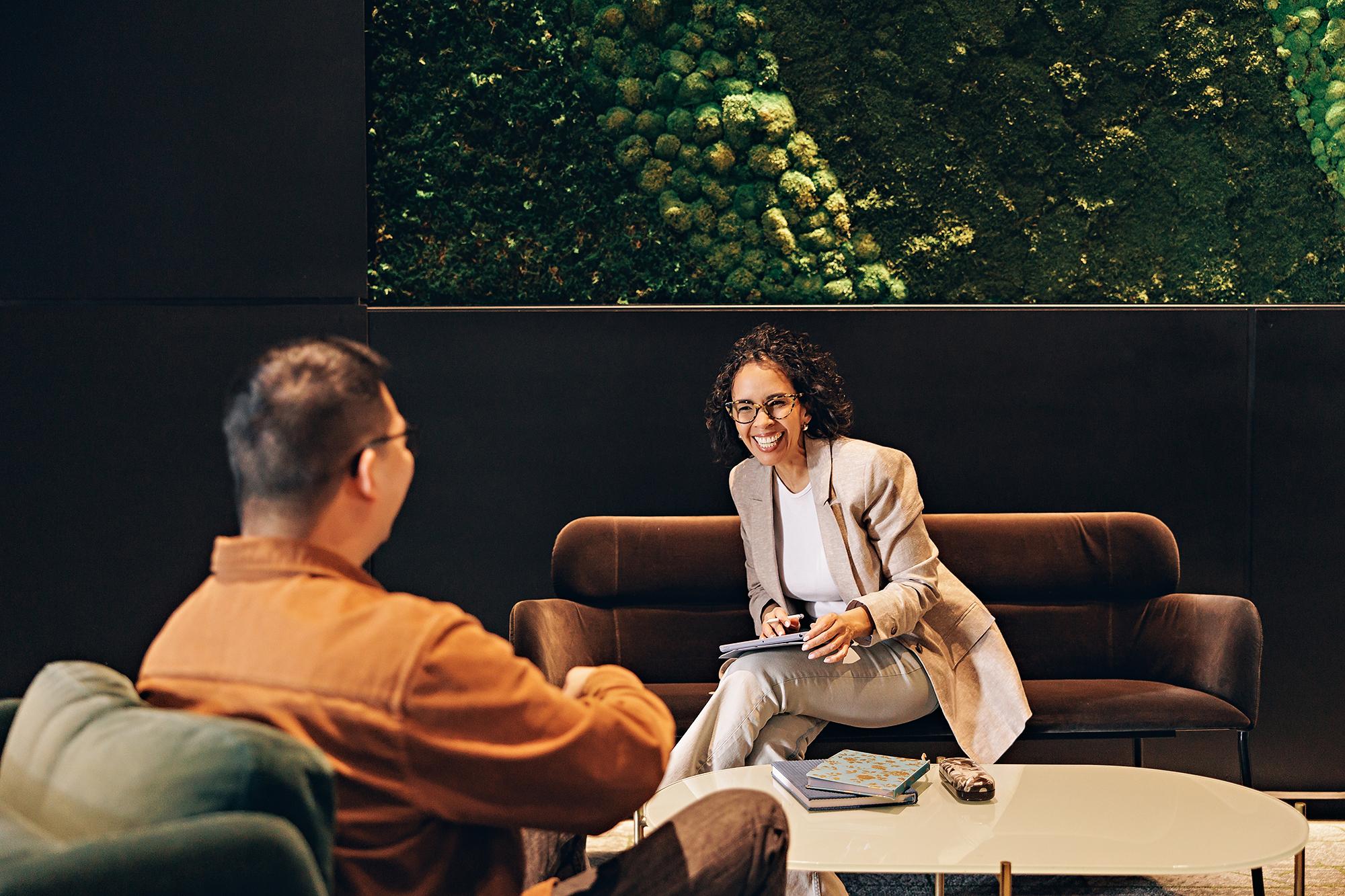 Calgary personal branding photographer: Female executive in a beige blazer holding a tablet during an office consultation