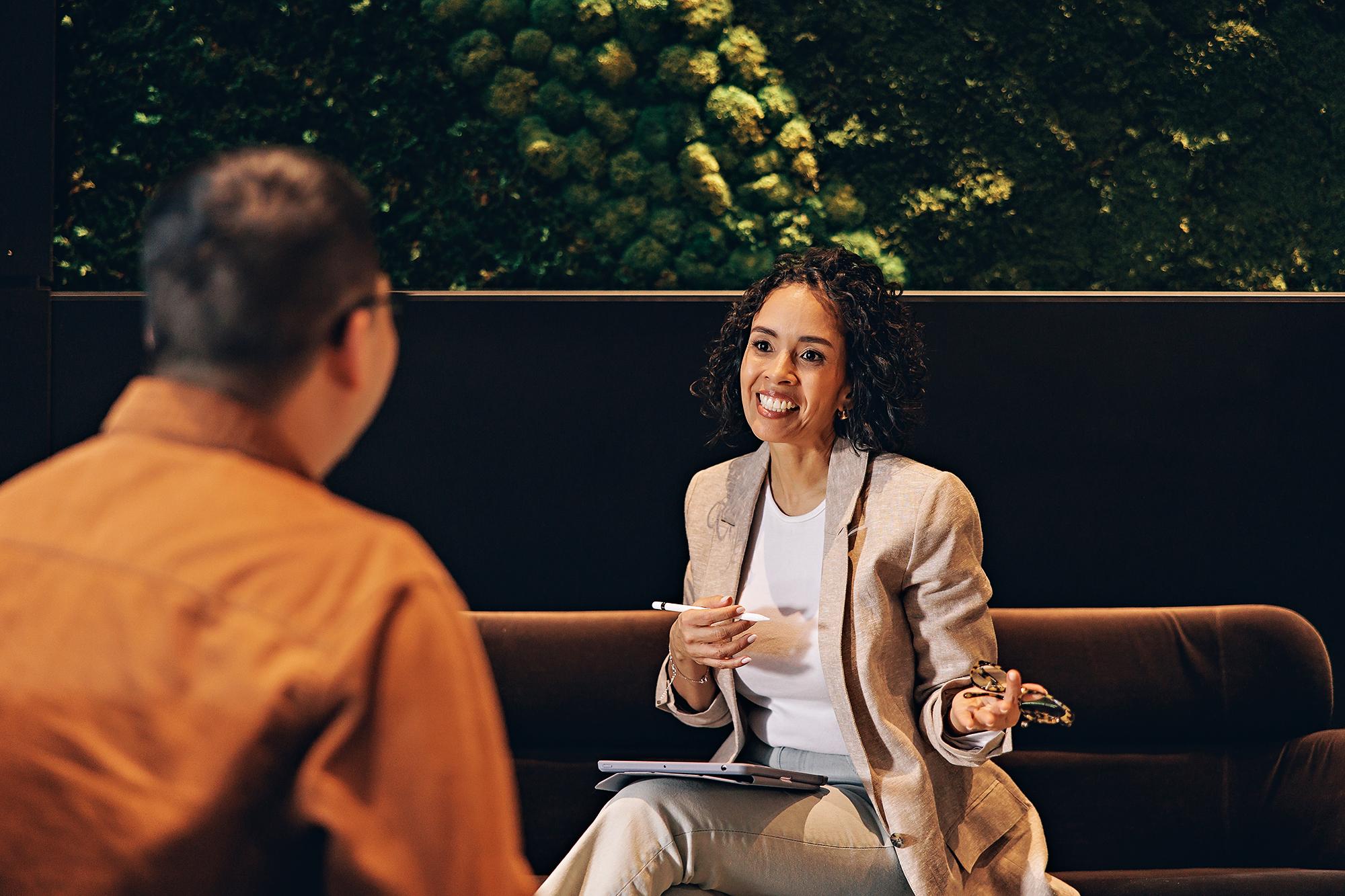 Calgary corporate portrait: Businesswoman holding a stylus pen and actively speaking during a workplace meeting