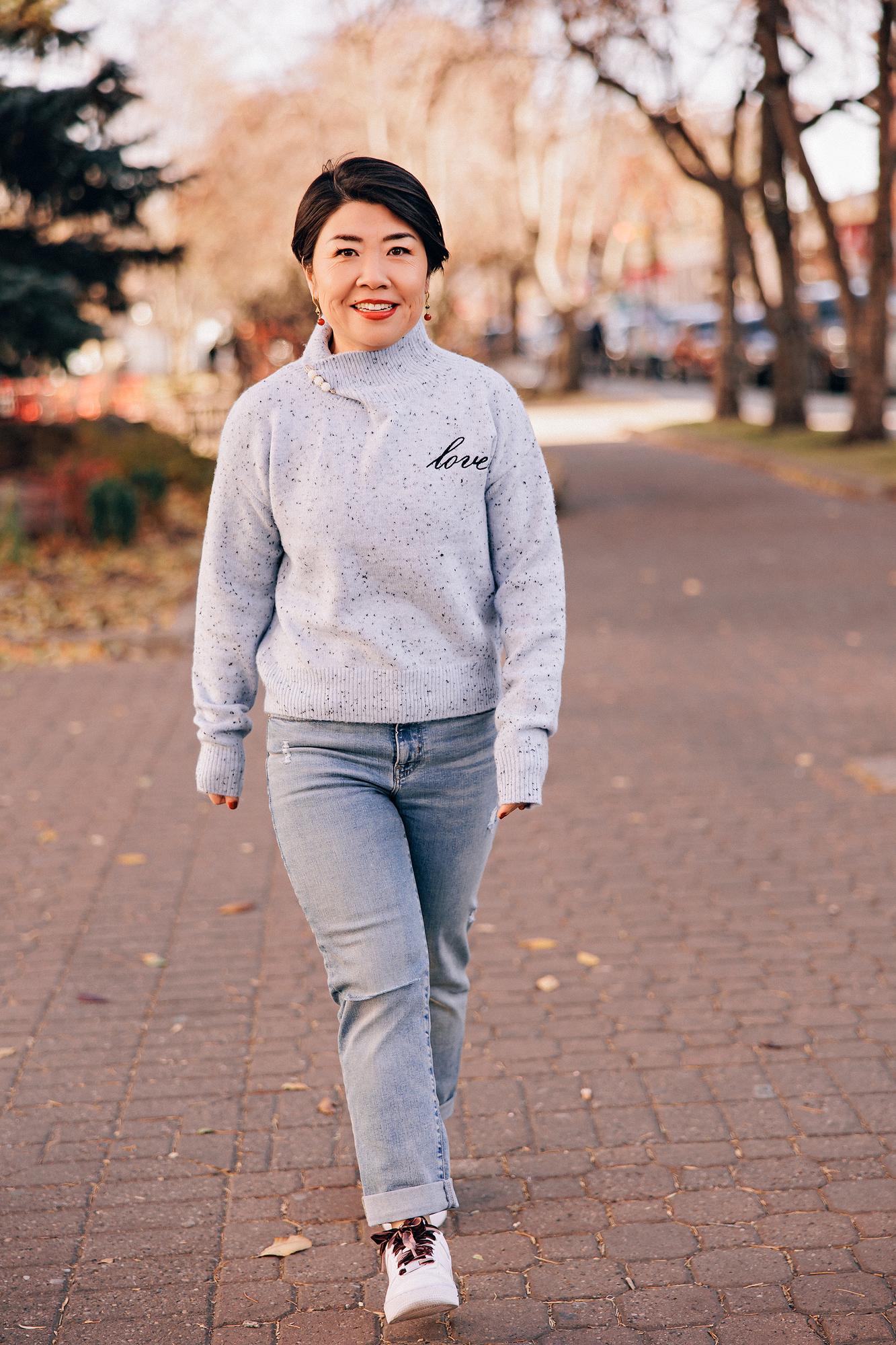Personal Branding photography Calgary: Woman strolling along a brick path lined with autumn trees